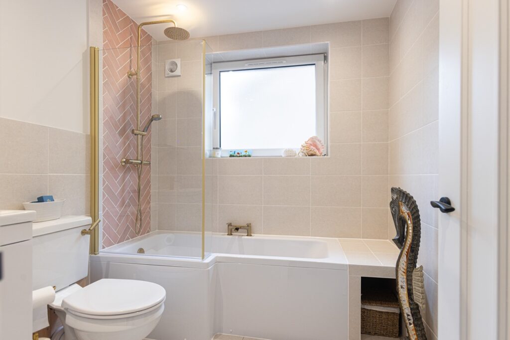 bathroom renovation with l shaped bath and pink tiles